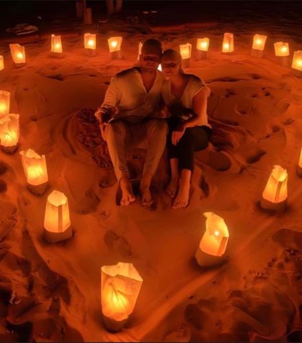 a man and woman sitting in a circle of candles at Wadi Rum, Hala bubbles in Wadi Rum