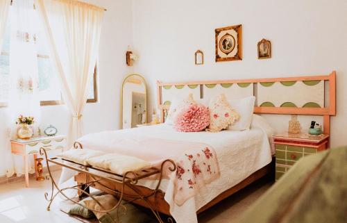 a bedroom with a large bed with pink pillows at Freijoó Casa Vintage in Papantla de Olarte