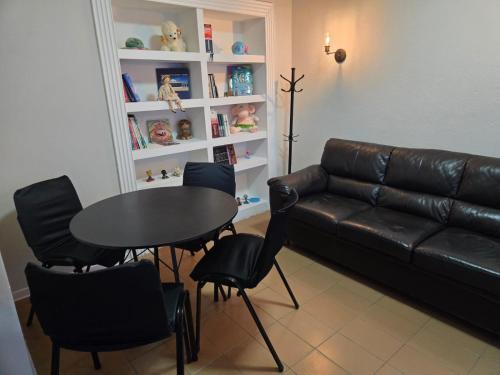 a living room with a leather couch and a table and chairs at Elegant House with Party Room in Santana do Livramento