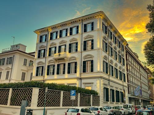 a large white building with cars parked in front of it at The Spotlight Boutique Hotel in Rome
