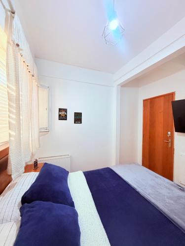 a bedroom with a blue and white bed and a window at MAKTVB Europa - Hostal Boutique in Santiago