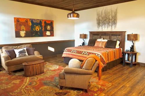 a bedroom with a bed and a couch and a chair at The Dogwood Inn in Blue Ridge