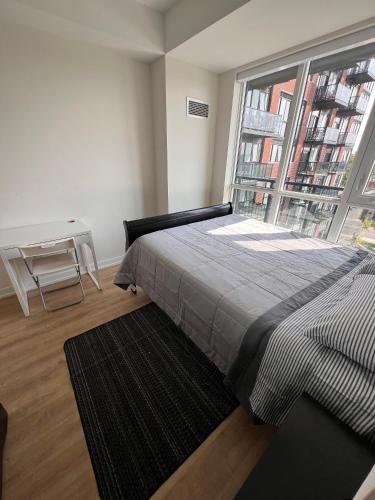 a bedroom with a bed and a large window at Vibrant 1 Bedroom Condo Apt in Toronto