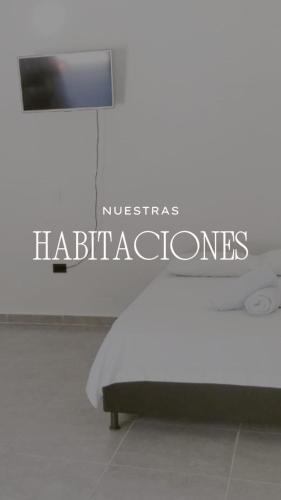 a bed in a room with a sign that reads nicabase habitats at JyM apartaestudios in Doradal