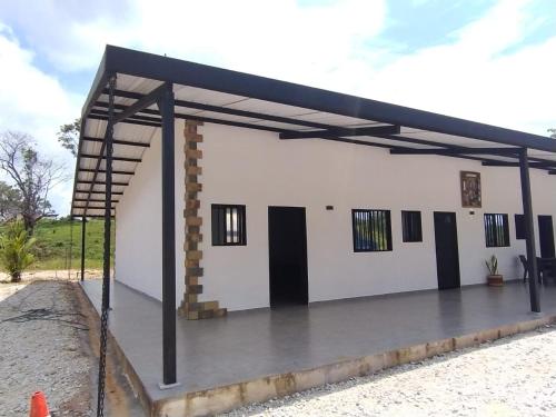 a large white building with a metal roof at JyM apartaestudios in Doradal