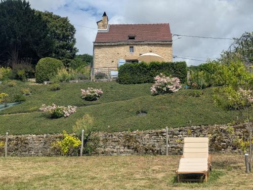 a house on top of a hill with a bench at Gîte de charme rénové avec terrasse et four à pain, proche de Langres et de la nature - FR-1-611-28 in Cohons