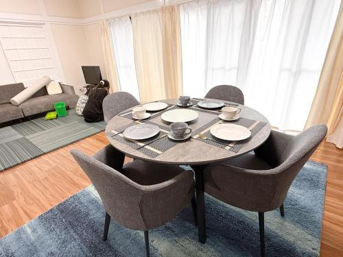 a dining room with a table and chairs in a living room at Center of Miyazaki, easy to access, 97square meters in Miyazaki