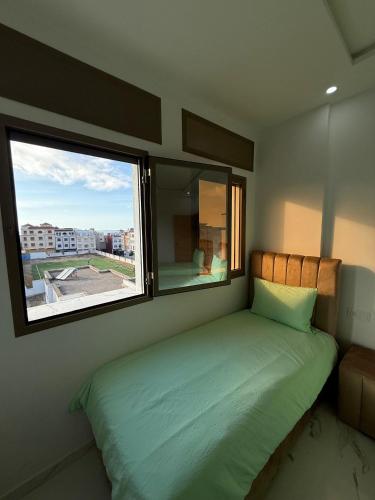 a bedroom with a bed with a large window at Nour DAsilah 8 in Asilah