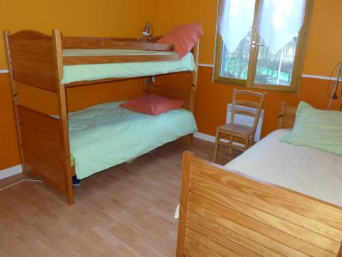 Zimmer mit 2 Etagenbetten und einem Stuhl in der Unterkunft Maison en bois au bord du canal avec terrasse et jeux - FR-1-611A-3 in Froncles
