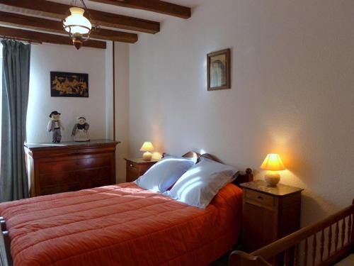 a bedroom with a bed with red sheets and white pillows at Maison restaurée avec piscine privée chauffée et équipements de loisirs à Bourmont-entre-Meuse-et-Mouzon - FR-1-611-58 in Bourmont
