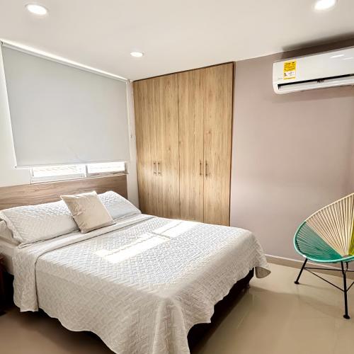 a bedroom with a bed and a cabinet and a chair at Apartamentos 438 in Ríohacha