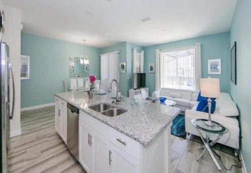 a kitchen with a sink and a couch in a room at Stunning Townhouses 5 Minutes away Disney! in Kissimmee