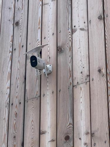 a security camera on the side of a wooden wall at Golden Ridge Apartments in Špindlerův Mlýn
