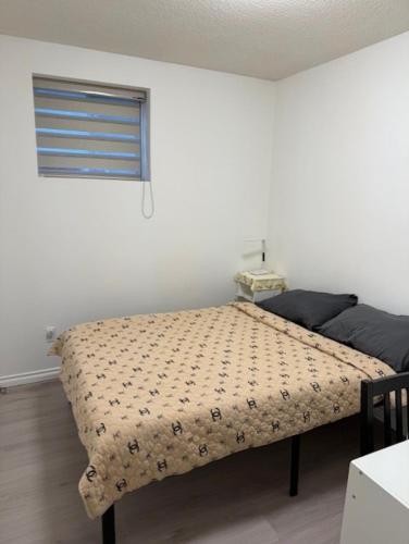 a bedroom with a bed with a blanket on it at Exclusive Offer - A special deal ending soon!! Super Nice Location - Very close to YVR Airport and shopping center & easy transportation in Vancouver