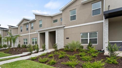 an apartment building with plants in the front yard at Stunning Townhouses 5 Minutes away Disney! in Kissimmee
