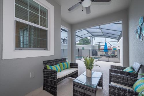 a living room with two chairs and a table at Stunning Townhouses 5 Minutes away Disney! in Kissimmee