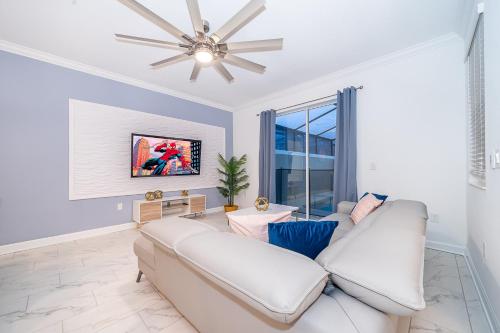 a living room with a white couch and a ceiling fan at Stunning Townhouses 5 Minutes away Disney! in Kissimmee