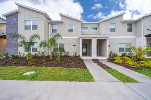 a large apartment building with a driveway at Stunning Townhouses 5 Minutes away Disney! in Kissimmee