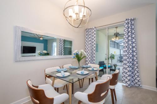 a dining room with a table and chairs and a mirror at Stunning Townhouses 5 Minutes away Disney! in Kissimmee