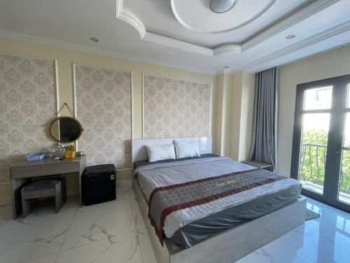 a bedroom with a bed and a desk and a window at RUBY HOTEL in Tây Ninh