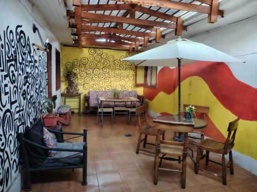 a room with a table and chairs and an umbrella at hostal playera in Constitución