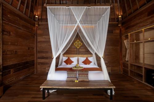a bed in a room with a canopy at Yana Villas Kemenuh by GenuineHost in Ubud