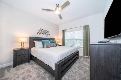 a bedroom with a bed and a flat screen tv at Stunning Townhouses 5 Minutes away Disney! in Kissimmee