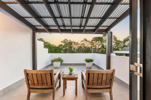 a patio with a table and two chairs at Perfectly located Noosa Hill Oasis w private pool in Noosa Heads