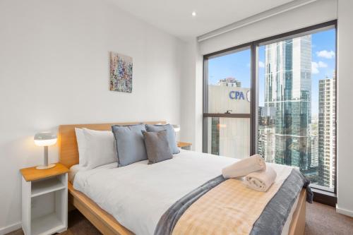 a bedroom with a bed and a large window at Astra Apartments Southbank Prima Pearl in Melbourne