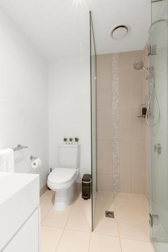 a bathroom with a toilet and a glass shower at Astra Apartments Southbank Prima Pearl in Melbourne