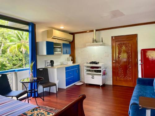a kitchen with blue cabinets and a table in a room at Ngermid Oasis-Spacious Studio With Kitchenette & Scenic Views in Koror