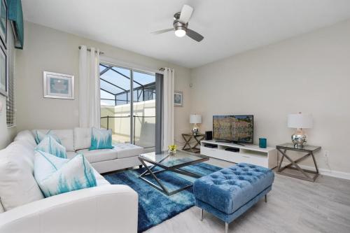 a living room with a white couch and a tv at Stunning Townhouses 5 Minutes away Disney! in Kissimmee