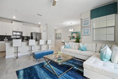 a living room with a white couch and a table at Stunning Townhouses 5 Minutes away Disney! in Kissimmee