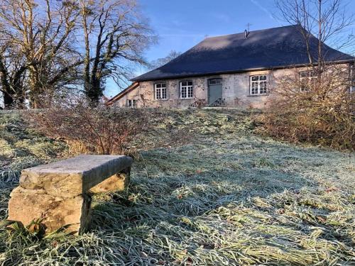 a stone bench sitting in front of a house at 3-bedroom holiday home with panoramic view in Haltinne