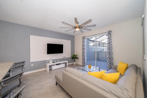 a living room with a couch and a tv at Stunning Townhouses 5 Minutes away Disney! in Kissimmee