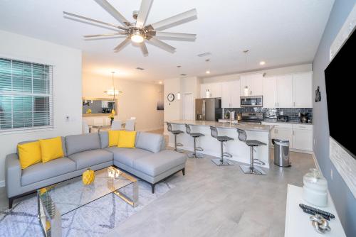 a living room with a couch and a kitchen at Stunning Townhouses 5 Minutes away Disney! in Kissimmee
