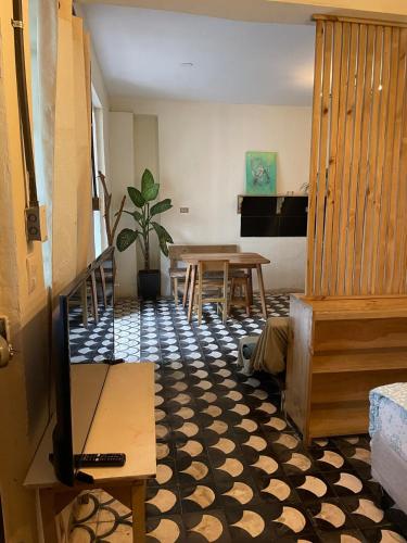 a living room with a television and a table at Amplio primer nivel centro histórico el círculo in Guatemala