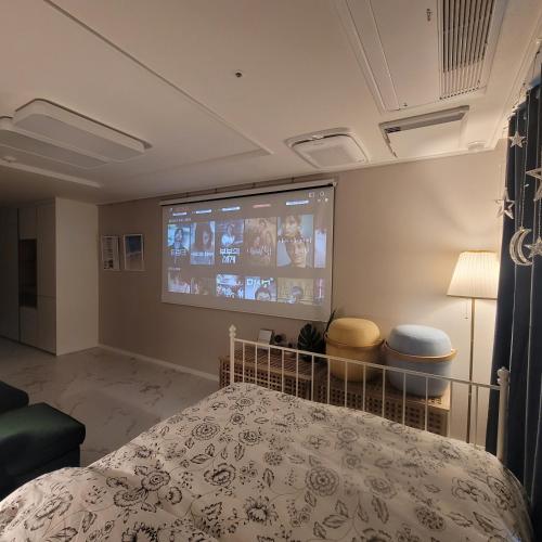 a bedroom with a bed and a projection screen at Sensation-나만의영화관,130인치대형스크린,넷플,디즈니플러스,장기숙박추천 in Namyangju