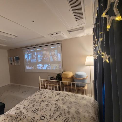 a bedroom with a bed and a projection screen at Sensation-나만의영화관,130인치대형스크린,넷플,디즈니플러스,장기숙박추천 in Namyangju