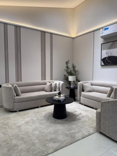 a living room with two couches and a table at شفق in Al Shafa