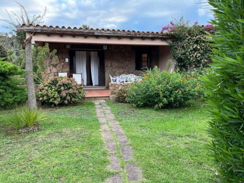 a stone house with a pathway leading to a yard at San Teodoro Beach Villa 86b in San Teodoro