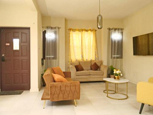 ブリッジタウンにあるCasa Amarilla St Michaelのリビングルーム(ソファ、椅子、ドア付)