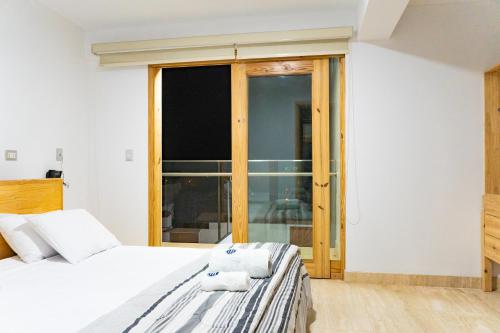a bedroom with a bed and a large window at Hospedaje La Angostura in Ica