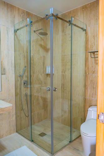 a glass shower in a bathroom with a toilet at Hospedaje La Angostura in Ica