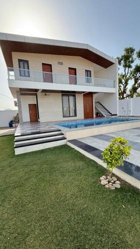 a large building with a lawn in front of it at Prime pearl villa in Thūr