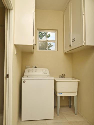 a small kitchen with a washer and a sink at Casa Amarilla St Michael in Bridgetown