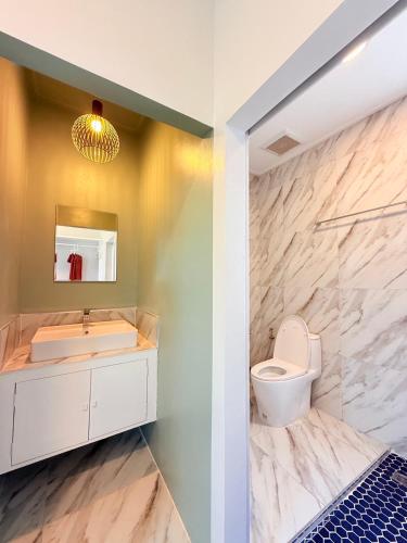 a bathroom with a sink toilet and a mirror at Kohtao Hillside resort in Ko Tao