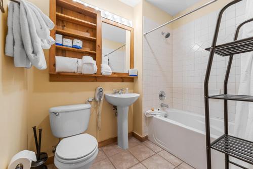 a bathroom with a toilet and a sink and a tub at Dakota Lodge 8512 by Summit County Mountain Retreats in Snake River Health Services Incorporated Heliport
