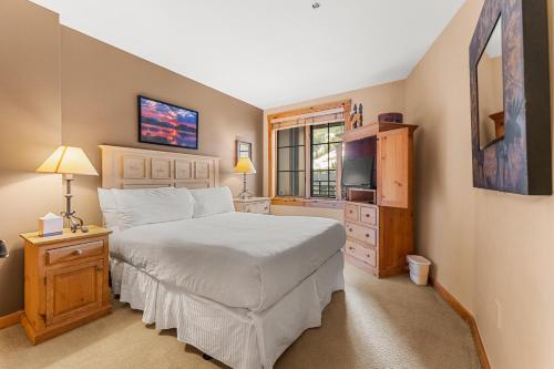 a bedroom with a white bed and a television at Dakota Lodge 8512 by Summit County Mountain Retreats in Snake River Health Services Incorporated Heliport
