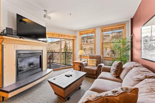 a living room with a fireplace and a tv at Silver Mill #8222 in Keystone